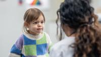 Young girls sits with doctor listening to instructions.